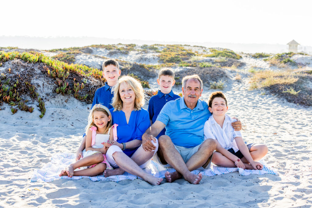 A Windy Evening with a Lifestyle Photographer San Diego Families Trust Extended family laughing together during their Coronado family beach photography session